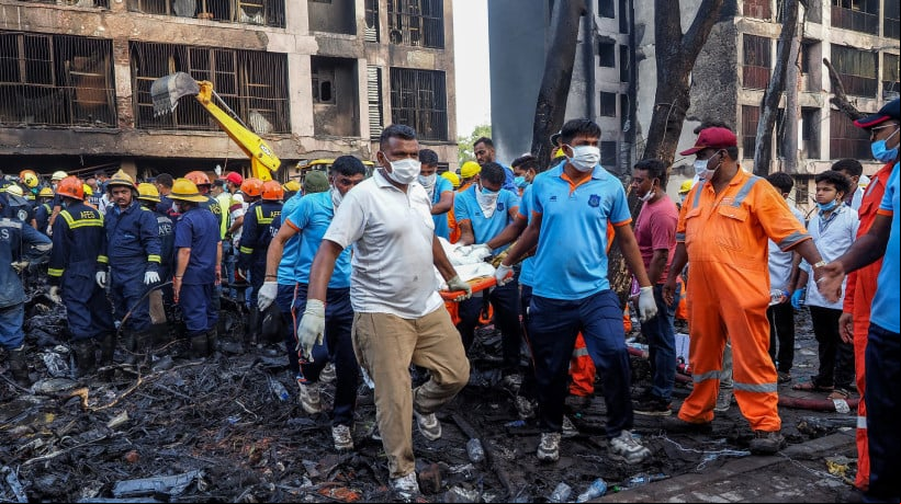 Equipes de resgate carregam o corpo de uma vÃ­tima no local onde o voo 171 da Air India caiu, em uma Ã¡rea residencial perto do aeroporto de Ahmedabad, em 12 de junho de 2025 